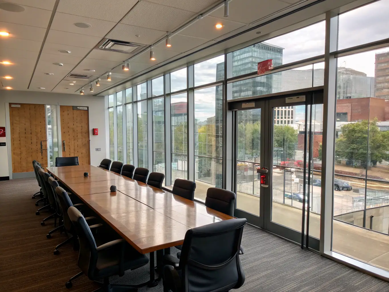 A sleek, modern office conference room with FYLM PDLC film installed on the glass partitions, providing on-demand privacy during meetings. The glass is clear when not in use, maintaining an open and collaborative environment.